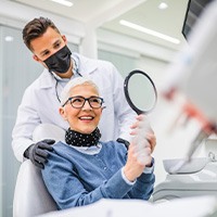 Woman pleased with her dentures at the dentist’s office 