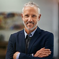 Male professional in suit showing off dentures