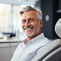 Man at the dentist’s office showing off new dental implant smile